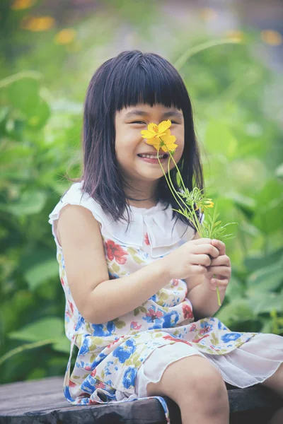 可爱的女孩，与黄波斯菊肖像花花束在汉 — 图库照片