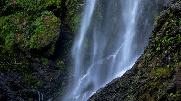 Nahaufnahme Wasserfall fließt zu Feuchtigkeitsfelsen Klippe im tiefen Wald — Stockfoto