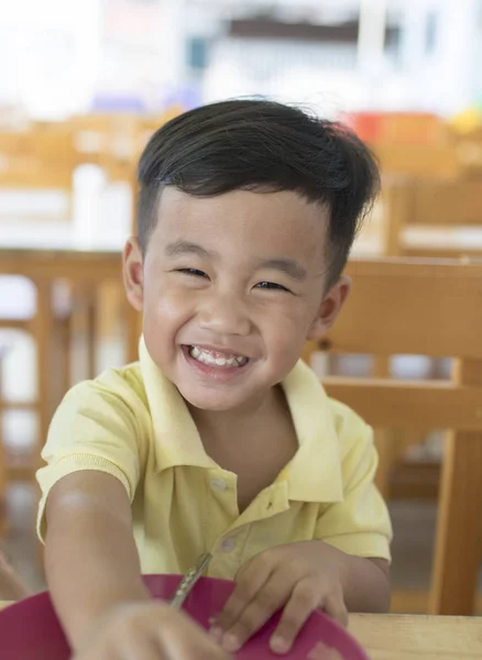 Toothy lachende gezicht geluk emotie van Aziatische kinderen zitten — Stockfoto