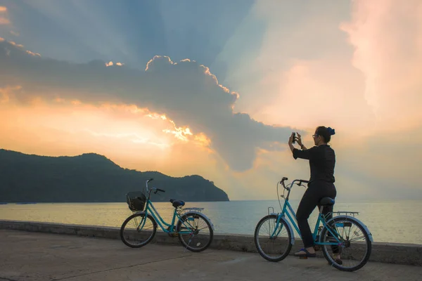 Woman on bicycle taking photograph by smart phone — Stock Photo, Image