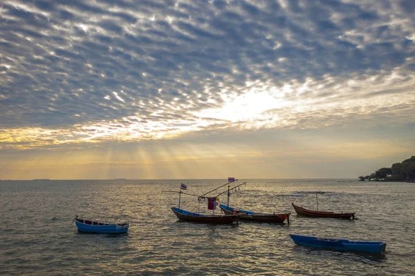 Barco de pesca nacional en el mar llano y dramático de nubes y sol — Foto de Stock