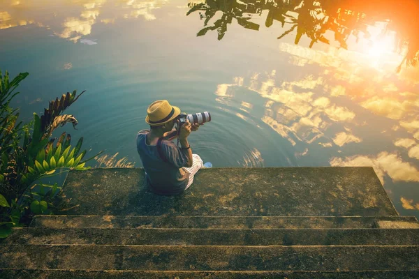 Hipster man een foto neemt op pier tegen mooie luchten — Stockfoto