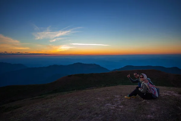 Parejas de hombres y mujeres sentados en la cima de la escena de la montaña con b —  Fotos de Stock