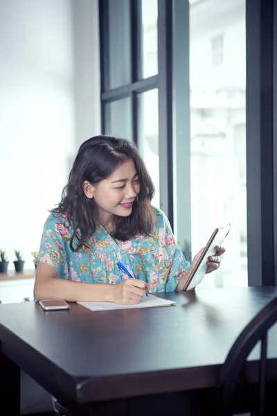 Jovem asiático mulher freelance assistindo e tablet computador e w — Fotografia de Stock