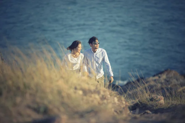 Paren van Aziatische jongere man en vrouw ontspannen aan zee strand — Stockfoto