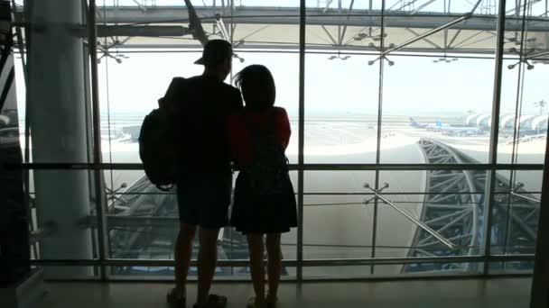 站在机场窗口的年轻夫妇简况 — 图库视频影像