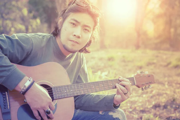 亚洲自由音乐家在户外对碧演奏民间吉他 — 图库照片