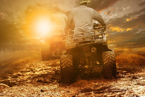 Uomo cavalcando ATV attraverso il campo di fango — Foto Stock