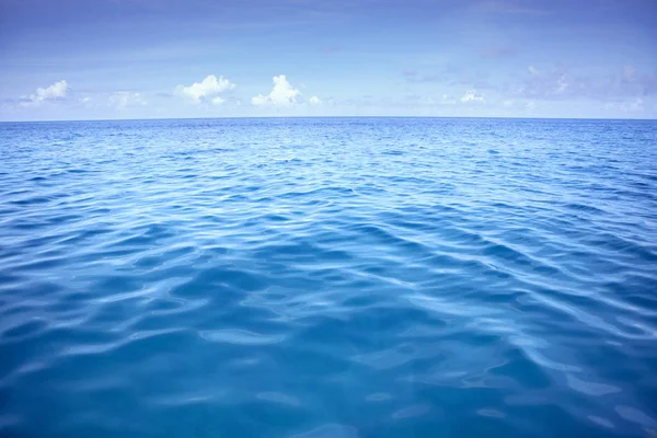Djupblå havet vatten med vita moln över himlen — Stockfoto