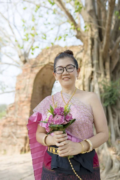 タイの女性が歯を見せて笑顔ピンクの蓮の花を手に — ストック写真