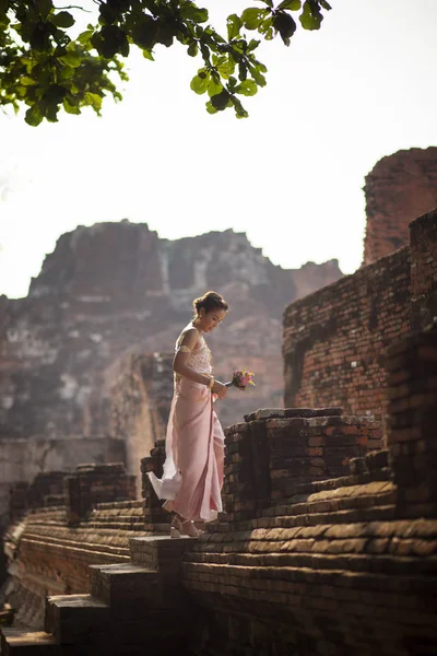 Güzel Asyalı kadın ile antik üzerinde pembe lotus çiçek duran — Stok fotoğraf