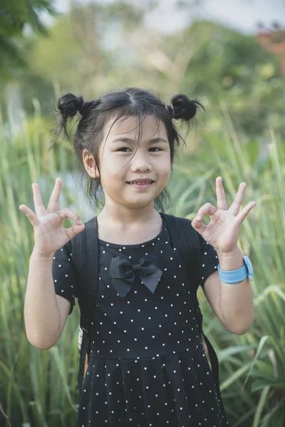 Aziatische kinderen permanent buiten en hand teken goed, ok — Stockfoto