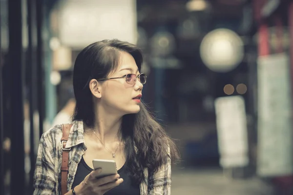 Close up face of asian younger woman holding smart phone in hand — Stock Photo, Image