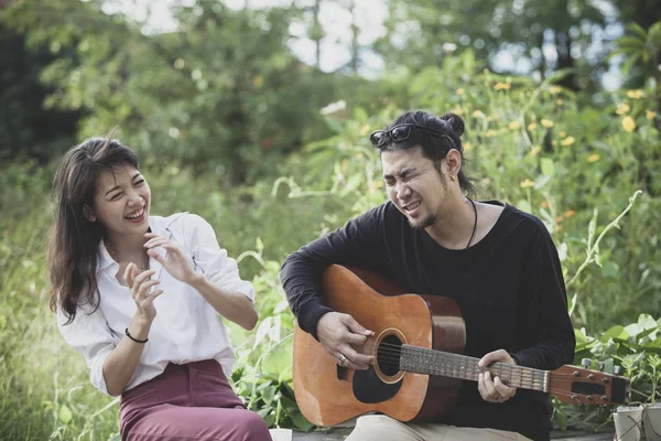 亚洲年轻男子和女子弹吉他与幸福情感 — 图库照片