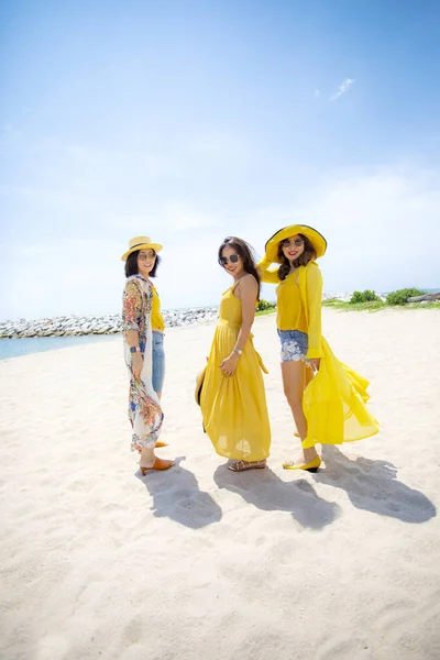 Schöne asiatische Frau in gelben Kleidern steht auf Meer bea — Stockfoto