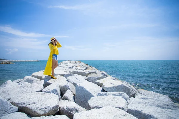 穿着黄色衣服站在海面上的美丽的亚洲女人a — 图库照片