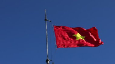 Vietnam bayrağı açık mavi gökyüzüne karşı dalgalanıyor