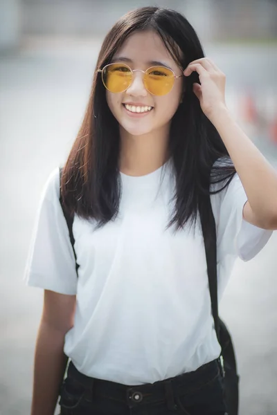 Ganska asiatisk tonåring bär glasögon stående utomhus — Stockfoto