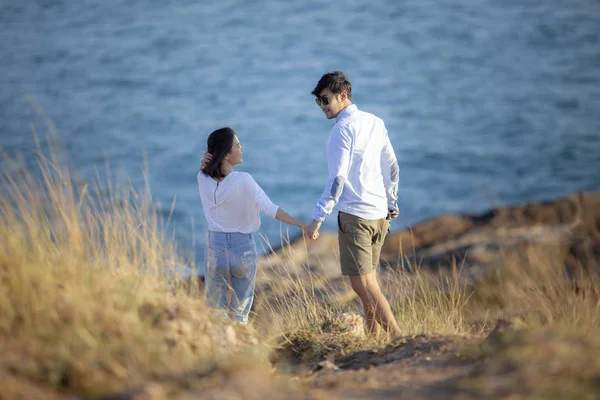 Молодые пары расслабляют эмоции счастья на отдыхе на берегу моря — стоковое фото