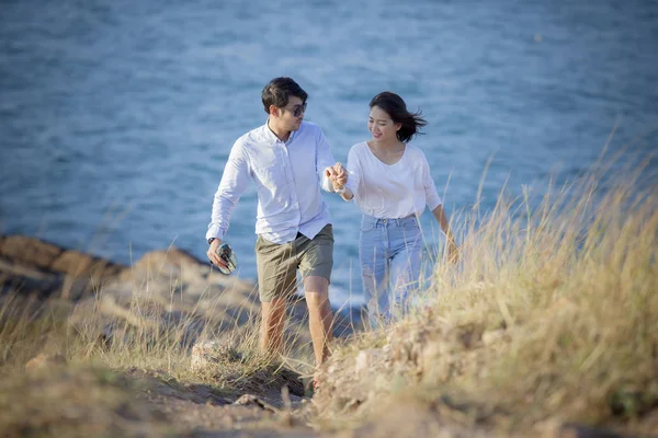 Paren van Aziatische jongere man en vrouw ontspannen aan zee strand — Stockfoto