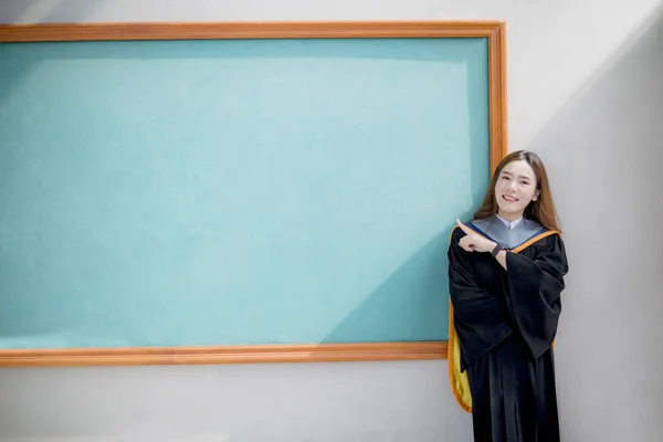 Ασιάτισσα Νεότερη Γυναίκα Φορώντας Κοστούμι Αποφοίτησης Πανεπιστημίου Στέκεται Μπροστά Από — Φωτογραφία Αρχείου