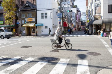 osaka japan - november8,2018 : unidentified man wearing surgical mask riding bicycle on osaka street town