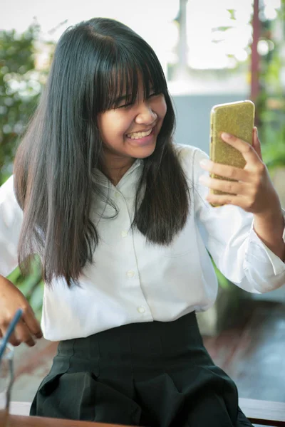 Asiatischer Teenager Lächelt Vor Glück Und Blickt Auf Smartphone Bildschirm — Stockfoto