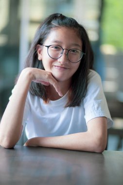 Gözlük takan Asyalı bir gencin gülen yüzü. 