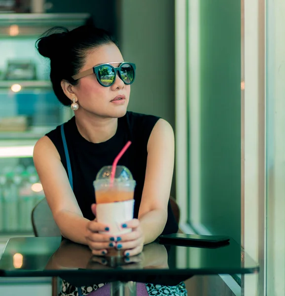 Güzel Asyalı Kadın Soğuk Içecek Şişesiyle Kafeteryada Oturuyor — Stok fotoğraf