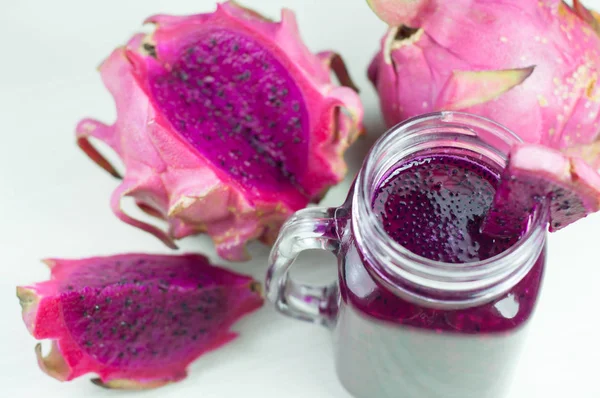 Kırmızı dragon meyve suyu ve taze dragon meyve, closeup beyaz tahta üzerine