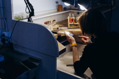 Kuyumcu tezgahındaki bir mücevher parçasıyla çalışıyor. El sanatları insanları sanat konsepti. Gümüş yüzük yapıyor..