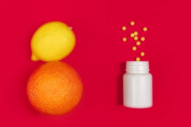 Virüs enfeksiyonlarına karşı bağışıklık kazanmak. Vitaminli beyaz şişe ve karşı tarafta kırmızı arka planda taze meyve. Düz yatıyordu. Coronavirus, karantina, evde kalma kavramı