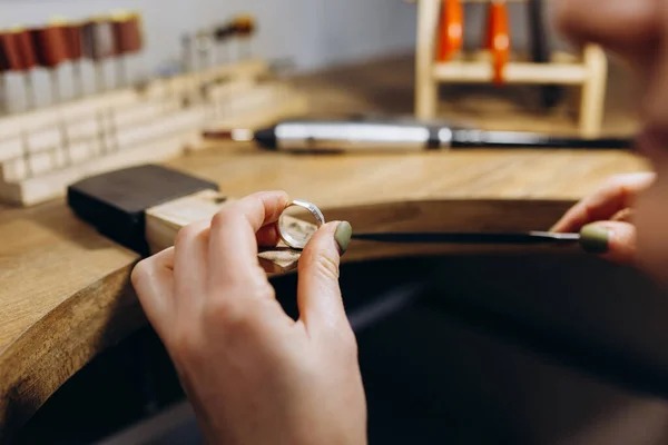 Woman hands close up making silver jewelry top view preparation process dark. Working tools on the table. Handicraft people art concept. She makes silver ring.