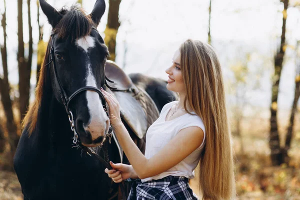 田舎で馬に乗って笑って立っている美しい若い女性の肖像画 — ストック写真