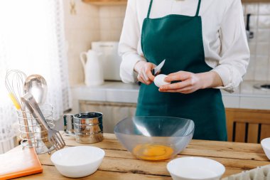 Kapalı kadının elleri para için yumurtayı bir kasede kırar. Ev yemeği konsepti