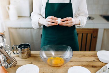 Kapalı kadının elleri para için yumurtayı bir kasede kırar. Ev yemeği konsepti