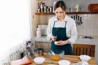 Genç güzel bir kız masada mutfakta duruyor ve kek pişirecek. Yemek blogu yazarı. Sağlıklı yaşam tarzı. Evde yemek pişirmek. Ketojenik diyet ve menü