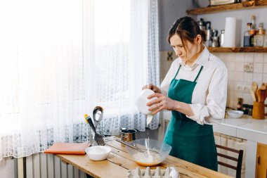 Mutfaktaki genç kadın evde Belçika Waffle 'ı pişiriyor. Sağlıklı yaşam tarzı. Evde Pişirme. 