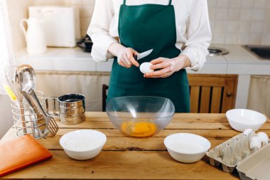 Kapalı kadının elleri para için yumurtayı bir kasede kırar. Ev yemeği konsepti