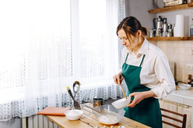 Mutfaktaki genç kadın evde Belçika Waffle 'ı pişiriyor. Sağlıklı yaşam tarzı. Evde Pişirme. 