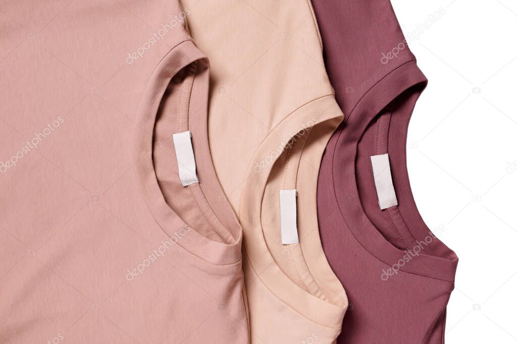 Three unisex basic blank t-shits in pastel colors isolated on white background. Top view. Capsule wardrobe concept. Creative flat lay. Minimal style. Pattern. Trendy clothes collage.