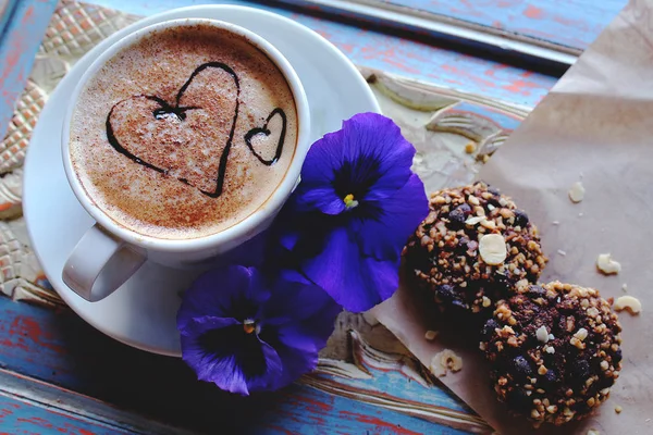 Утренний капучино с сердцами, печеньем и цветами — стоковое фото