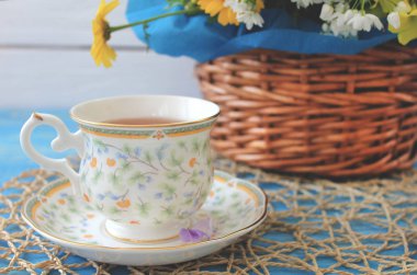 Bir fincan çay ahşap bir mavi masa üzerinde renkli fi bir buket