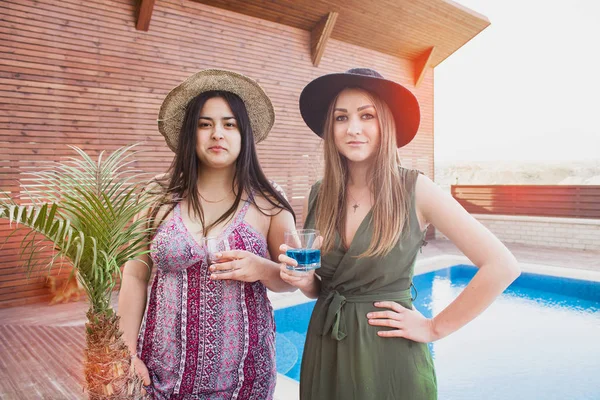 两个漂亮的女孩在花园里喝鸡尾酒。封闭的朋友 — 图库照片