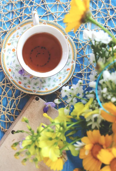 Чашка чая на деревянном синем столе с букетом цветной фай — стоковое фото