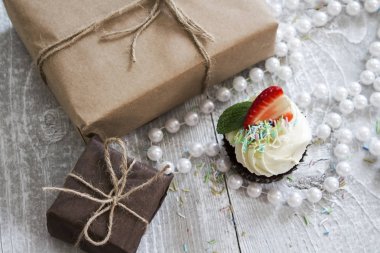 Hediye kutuları ve beyaz krem ve çilek ile çikolatalı kek