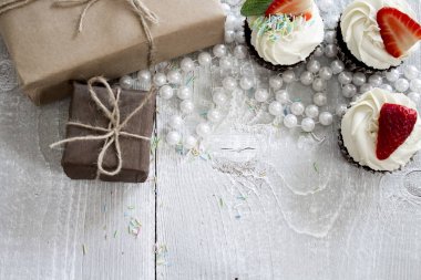 Hediye kutuları ve beyaz krem ve çilek ile çikolatalı kek