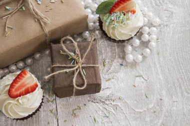 Hediye kutuları ve beyaz krem ve çilek ile çikolatalı kek