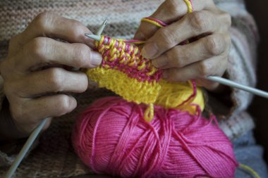 Kadınların elleri tutun örgü iğneleri ve kravat için sarı bir iplik 