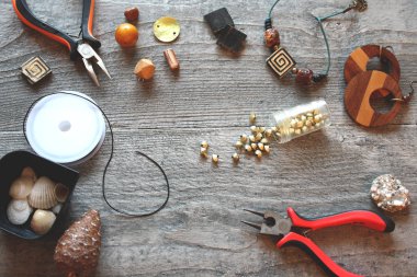 siyah bir iş parçacığı üzerinde el yapımı renkli boncuklar ahşap bir masaya yalan 